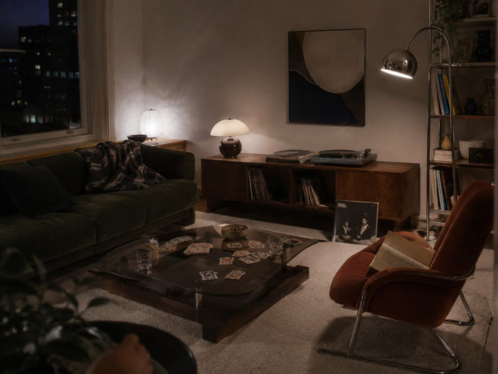Screen-free living room with books, records and layered evening light