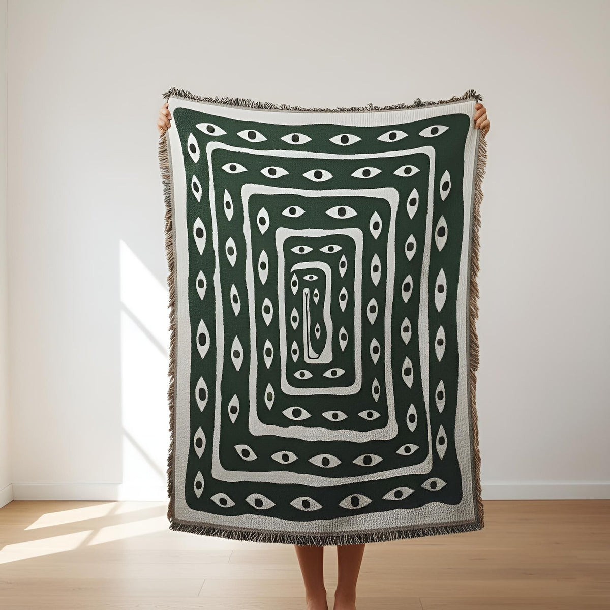 Mystic Gaze woven throw styled with deep green and ivory eye artwork