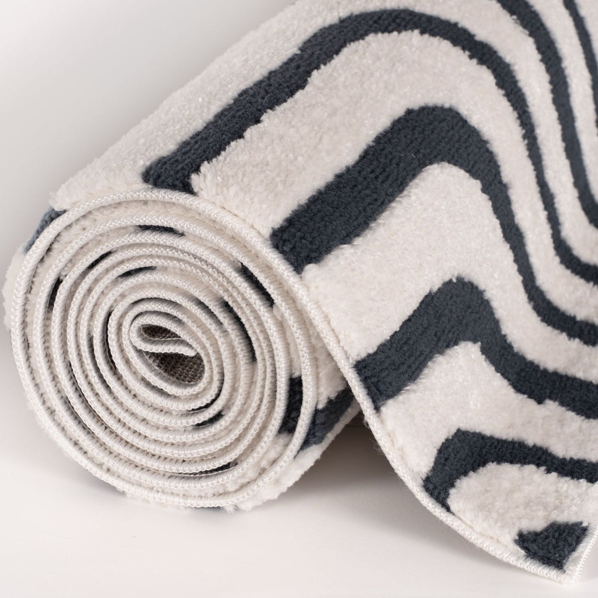 Cobalt Frame Rug — rolled side view