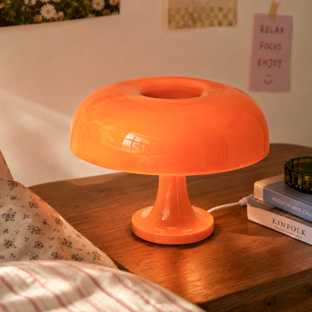 Sculptural orange mushroom desk lamp glowing in a modern interior